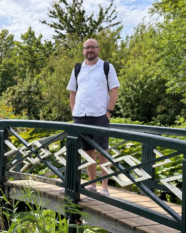 Brandon Seibel, founder of Trip7, on a garden footbridge